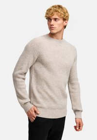 Helles graues, geripptes Strickpullover mit Rundhalsausschnitt und langen Ärmeln, aus weichem Material gefertigt, mit legerem Schnitt und subtilen Texturdetails.