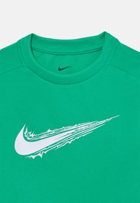 T-shirt vert Nike avec un col rond, arborant un logo swoosh blanc dynamique sur le devant, fabriqué en tissu respirant avec une finition texturée.