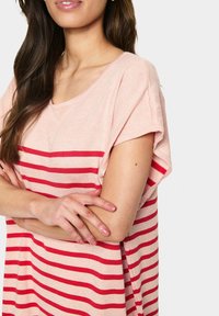 Top a righe rosa chiaro con strisce orizzontali rosse, maniche larghe e scollo a V. Tessuto morbido con una vestibilità comoda.