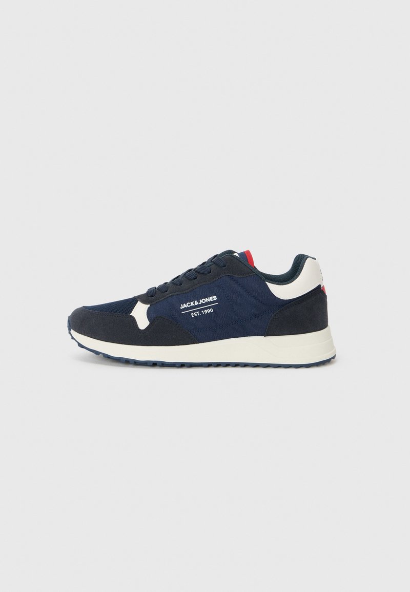 Mørkeblå sneakers med en kombination af mesh- og ruskindsmaterialer, kontrasterende hvide accenter, en struktureret sål og et fremtrædende mærkelogo.