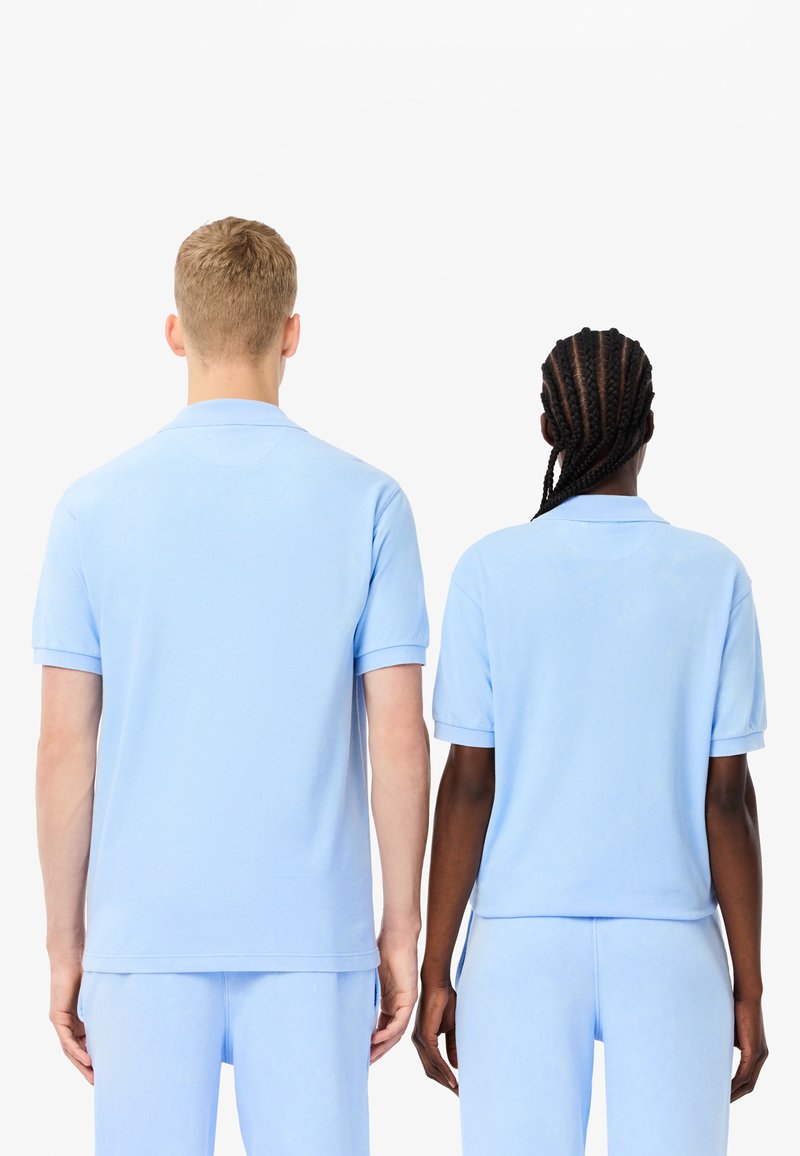 Niebieskie koszulki polo z miękkiej bawełny, z krótkimi rękawami i klasycznym kołnierzykiem. Obie koszulki mają luźny krój i bezszwowe wykończenie pleców.