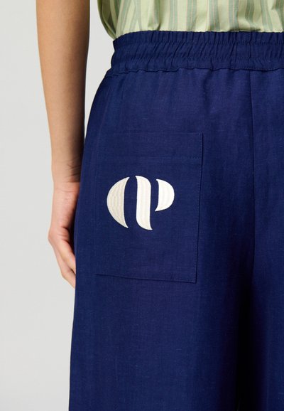 Pantaloni blu navy con una vestibilità comoda, dotati di una cintura elastica e una tasca posteriore decorata con dettagli del logo ricamato in bianco.
