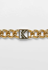 Guldkædearmbånd med store sammenkoblede led og en firkantet lås med et indgraveret logodesign. Glat, skinnende metalfinish.