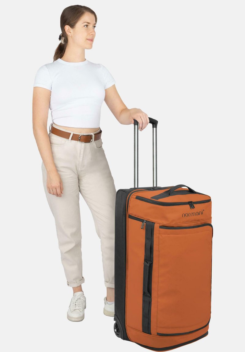 Große orange Reisetasche mit schwarzen Akzenten, glattem Stoff, ausziehbarem Griff und Rollen. Verfügt über mehrere Reißverschlusstaschen zur Aufbewahrung.