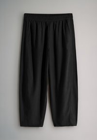 Pantalon noir à coupe ample avec taille élastique et poches latérales, présenté sur un fond gris clair.