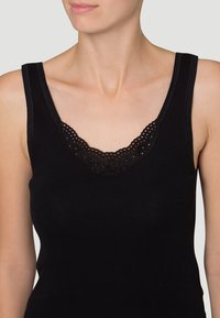 Black sleeveless top with a scoop neckline featuring intricate lace detailing at the collar, made of smooth, stretchy fabric.