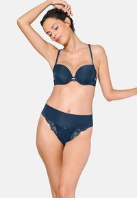Ensemble de lingerie marine comprenant un soutien-gorge rembourré avec des accents en dentelle et des bretelles ajustables, associé à une culotte assortie combinant des panneaux lisses et texturés.