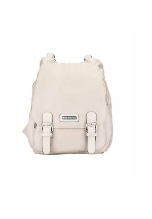 Zaino beige realizzato in tessuto morbido e durevole. Dotato di spallacci regolabili, due fibbie frontali e una placca con logo del marchio. Design compatto.