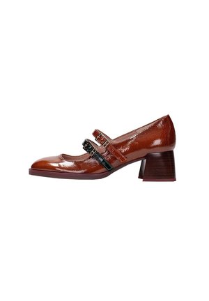 Zapatos Mary Jane de charol marrón con dos correas de hebilla negra, punta redonda y un tacón bajo de madera texturizada.