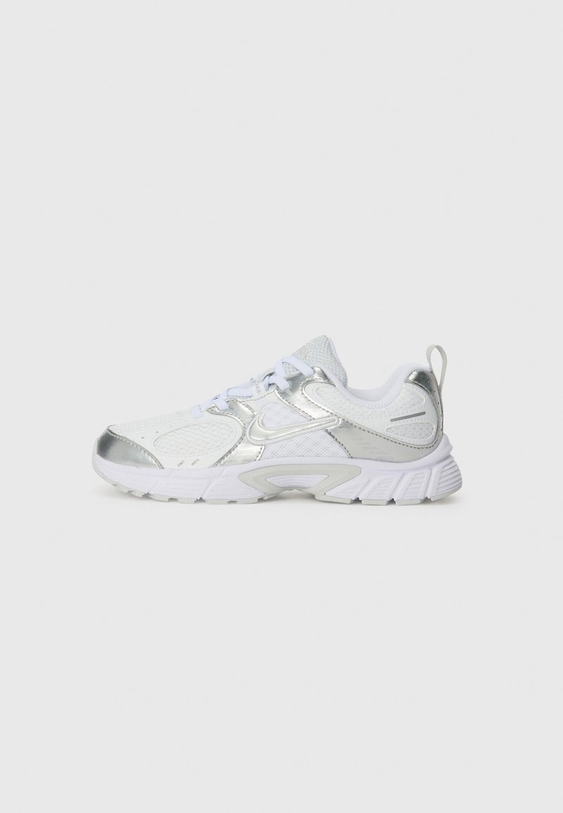Chaussure de sport blanche avec des accents métalliques argentés, tige en mesh, col rembourré et semelle texturée. Présente un système de laçage et une languette.