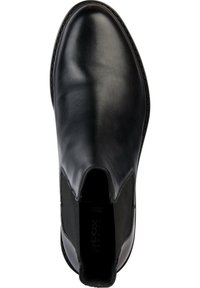 Botín negro de cuero con paneles laterales elásticos, textura suave, puntera redondeada y suela texturizada. Marca visible en la plantilla.