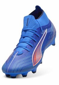 Scarpino da calcio blu con design di calzino alto, lacci e un logo a strisce bianche e arancioni sul lato, caratterizzato da motivi testurizzati.