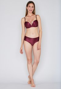 Ensemble bikini bordeaux côtelé comprenant un soutien-gorge légèrement rembourré avec bretelles ajustables et des culottes taille haute assorties. Texture lisse.