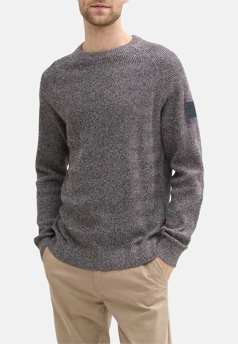 Pull en tricot avec un motif en chevron multicolore, col rond, manches longues, poignets côtelés et un petit logo brodé sur la manche gauche.