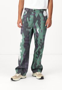 Pantalons en denim à motifs en losanges verts et violets, à coupe droite, cinq poches et fermeture à bouton standard à la taille.
