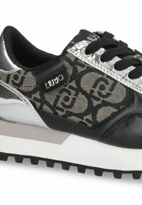 Black and silver sneakers featuring a patterned fabric upper with a shiny silver accent, black laces, and a textured black rubber sole.