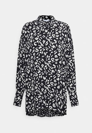 Black shirt with white abstract pattern, long sleeves, collar, and button closure. Lightweight fabric with a straight-cut hem and relaxed fit.