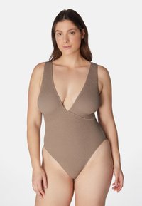 Ruskea teksturoitu yksiöinen uimapuku syvällä V-muotoisella kaula-aukolla, leveillä olkaimilla ja korkealla leikkuulla, jossa on ribbitoitu neulottu kangas lisäyksinä.