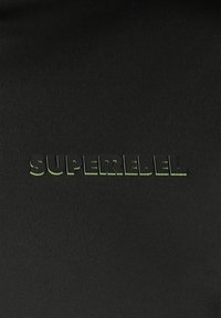 Glanzende zwarte stof met het woord "SUPERREBEL" in reflecterende zwarte tekst in het midden.