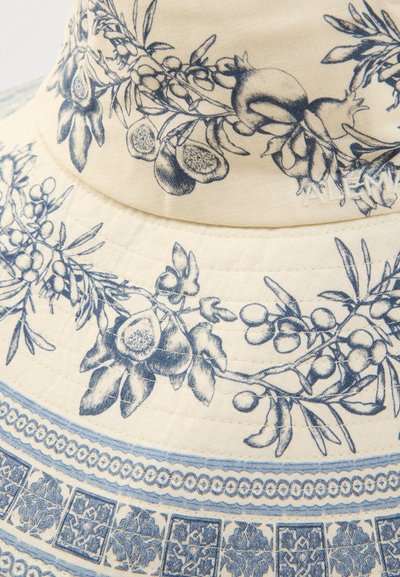 Λευκό ύφασμα καπέλο κουβά με μπλε βοτανικές απεικονίσεις, που περιλαμβάνουν φρούτα και φύλλα, με διακοσμητικά μοτίβα κατά μήκος της γείσος.