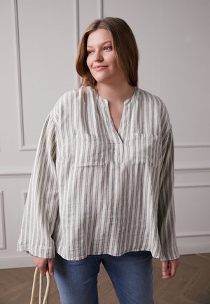 Blusa de manga longa, listrada em cinza e branco, com decote em V e dois bolsos frontais. Feita de um tecido texturizado com um corte relaxado.