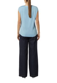 Top azzurro chiaro a maniche corte con scollatura rotonda, abbinato a jeans a gamba larga blu scuro con dettagli di cucitura discreti.