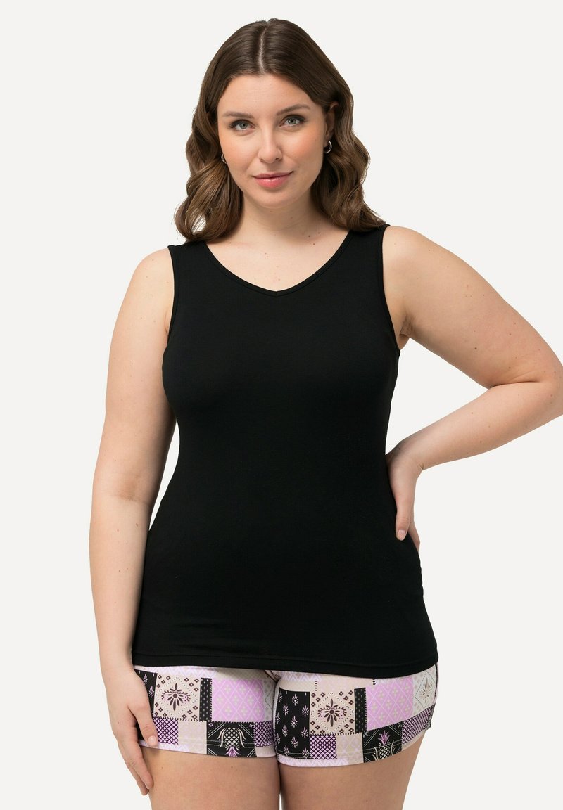 Schwarzes, ärmelloses Tanktop mit V-Ausschnitt und glatter Textur, kombiniert mit gemusterten Shorts in Pink, Schwarz und weißen Flecken.