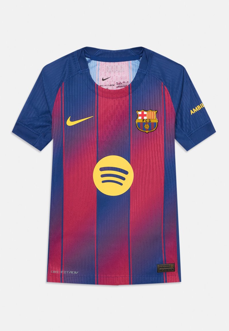 FC Barcelona krekls ar vertikālām sarkanām un zilām svītrām, Nike logo dzeltenā krāsā, Spotify logo dzeltenā krāsā, apaļa kakla izgriezums un īsas piedurknes.