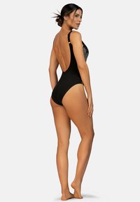 Czarny jednoczęściowy kostium kąpielowy z nisko wyciętymi plecami, regulowanymi ramiączkami oraz teksturowanym, graficznym wzorem na przodzie. Gładkie, matowe wykończenie.