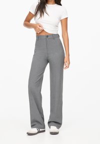Gray tailored trousers with a high waist, featuring a front button closure and back pockets. Smooth fabric and wide-leg design.