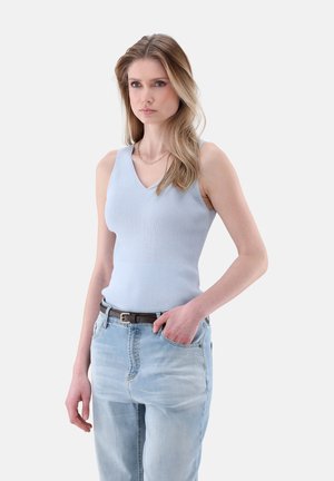 Top a righe azzurro chiaro con scollatura a V, abbinato a jeans blu sbiaditi e una cintura scura. Il tessuto sembra morbido e aderente.