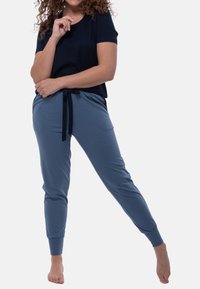 Mörkblå kortärmad skjorta i kombination med ljusblå joggerbyxor med elastisk midja och justerbar knytning, mjuk textur och sidofickor.