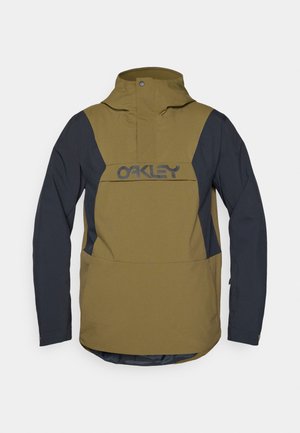 Olivgrüne und marineblaue Windbreaker-Jacke mit hohem Kragen, großer Fronttasche und auffälligem schwarzem Logo. Verfügt über ein elegantes, stromlinienförmiges Design.