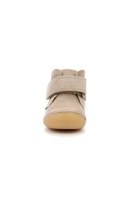 Zapato para toddler de ante beige con dos hebillas de velcro anchas y ajustables, puntera redonda y suela de goma flexible. Presenta costuras decorativas y un acento verde.