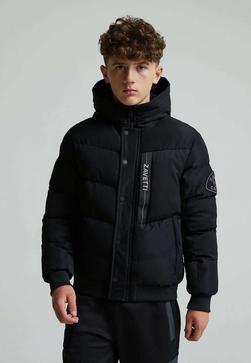 Veste en duvet noire avec un col haut, fermeture éclair et boutons, tissu texturé, et accents de logo sur la poitrine et la manche.