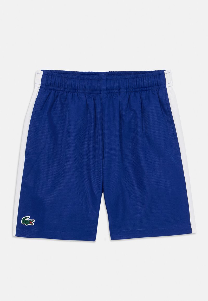 Zilā sporta šorti ar elastīgu jostu, baltām sānu svītrām un zaļu Lacoste logotipu apakšējā kreisajā pusē. Izgatavoti no elpojoša auduma.