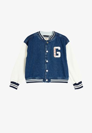 Denimjakke med hvide ærmer, ribbede manchetter og bund. Har et "G"-logo og teksten "Golf Challenge" broderet på brystet.