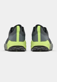 Γκρι αθλητικά παπούτσια με υφή στο πάνω μέρος, με έντονο λαχανί τακούνι και σόλα, και έντονο μοτίβο πέλματος στην εξωτερική σόλα.