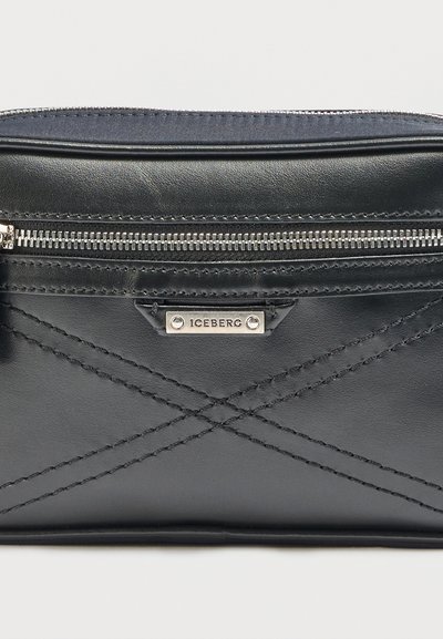 Μαύρο δερμάτινο τσαντάκι με διαγώνια ραμμένα σχέδια, ασημένιο φερμουάρ και μια μικρή ορθογώνια μεταλλική πλάκα χαραγμένη με τη λέξη "ICEBERG".