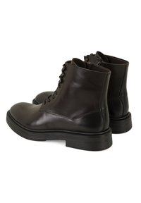 Bottines en cuir noir avec une finition lisse, à bouts ronds et à lacets, dotées d'un petit talon empilé et de détails de couture discrets.