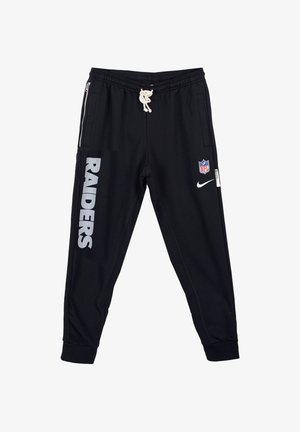 Czarne spodnie treningowe wykonane z miękkiego materiału, o zwężanym kroju, z dużym odblaskowym napisem "RAIDERS" i bocznymi kieszeniami na zamek.