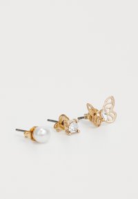 Département de boucles d'oreilles en plaqué or : une avec une perle blanche, une avec une pierre précieuse claire en sertissage griffé, et un design de papillon avec des découpes.