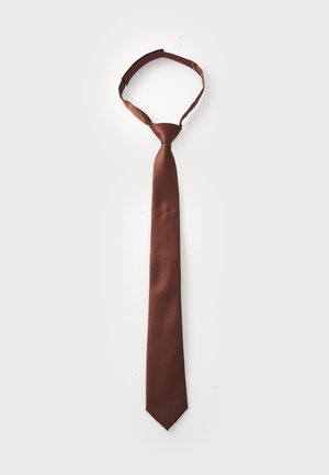 Cravate en satin marron, au design slim avec une pointe. Elle présente une texture lisse et un petit logo subtil en bas.