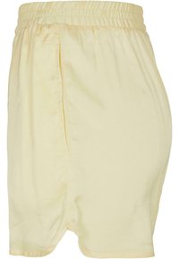 Pantaloni corti di cotone giallo chiaro con cintura elastica, tasche laterali e vestibilità comoda. Texture liscia e design semplice.