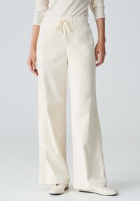 Wijdgevallen broeken van crème corduroy, met een elastische tailleband en een trekkoord, een gestructureerd oppervlak en zijzakken.