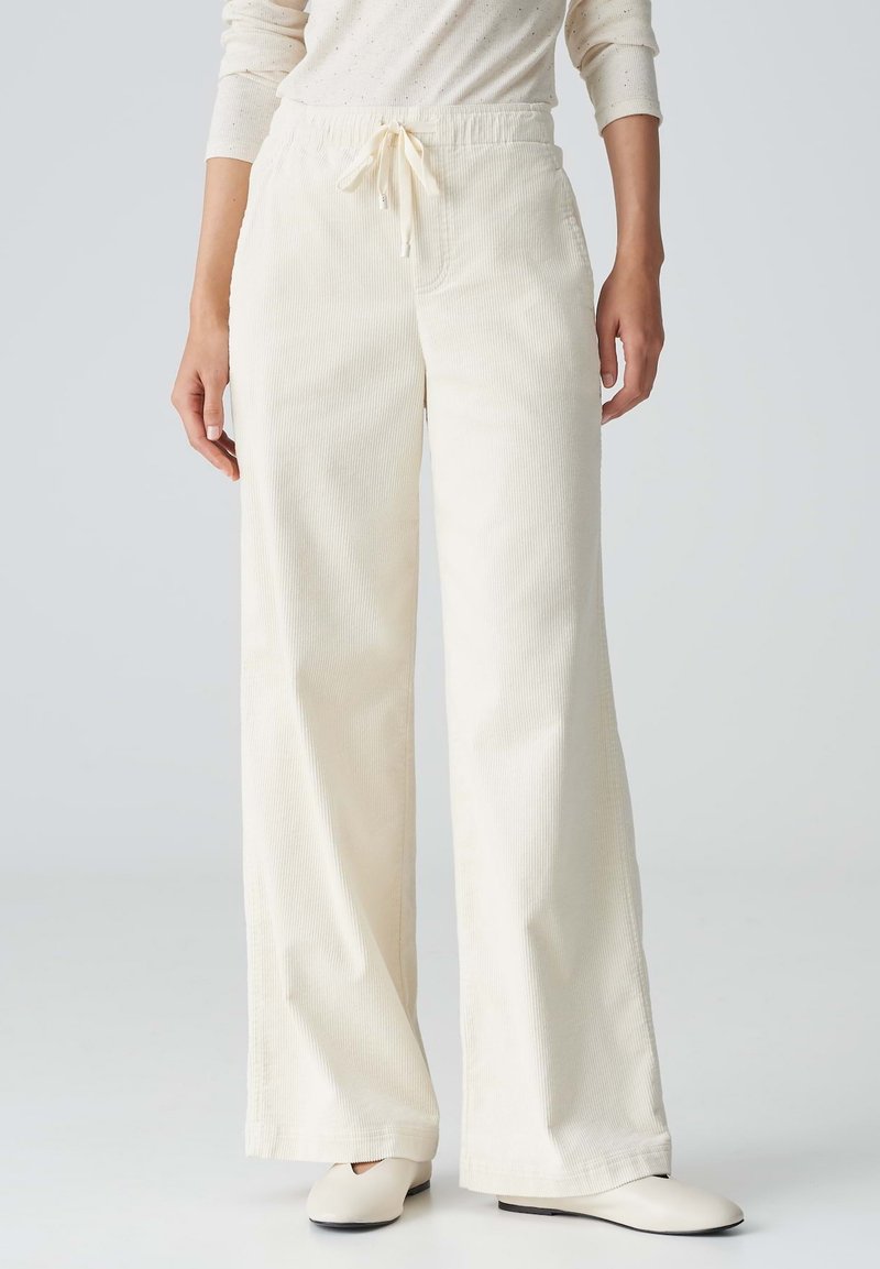 Wijdgevallen broeken van crème corduroy, met een elastische tailleband en een trekkoord, een gestructureerd oppervlak en zijzakken.