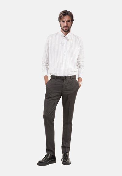 Witte gestreepte shirt met een vlinderdas, gecombineerd met donkergrijze op maat gemaakte broek en zwarte leren schoenen. Gladde stofstructuur, slim fit.