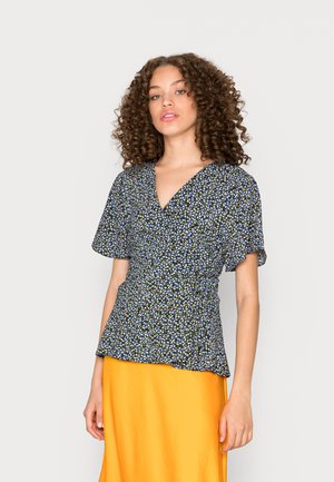 Topo floral envolvente em azul escuro com padrões amarelos e brancos, mangas curtas e cintura ajustada. Combina com uma saia amarela brilhante.