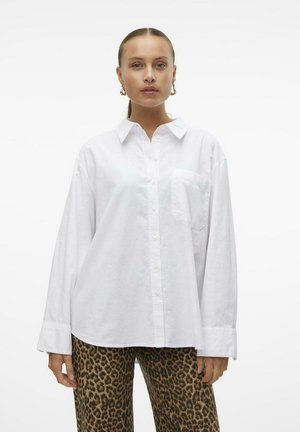 Hvid oversized button-up skjorte lavet af letvægtsstof, med en brystlomme og lange ærmer, parret med leopardprint bukser.