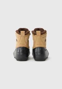 Braune und schwarze wasserdichte Stiefel mit Futter aus Fell, ausgestattet mit einer robusten Sohle, von hinten vor einem schlichten Hintergrund präsentiert.